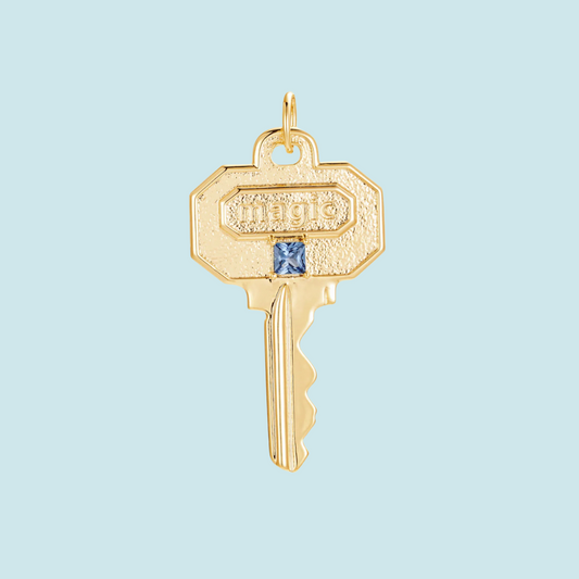 Gold key charm with 'magic' engraving 
